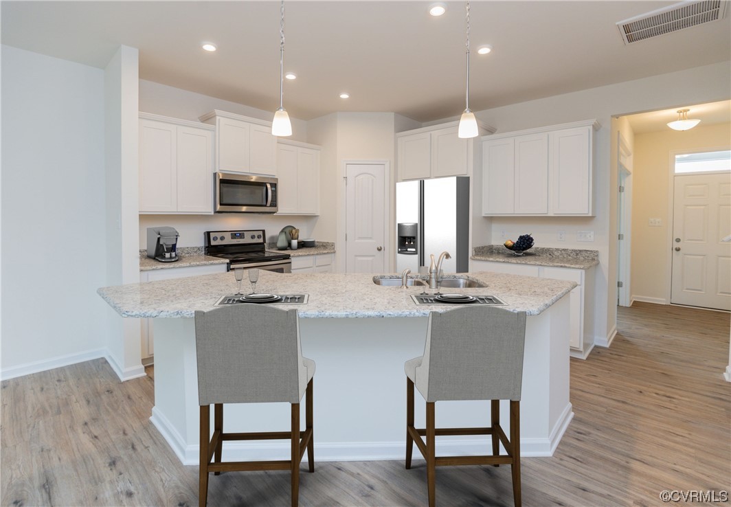 Photo represents the plan, not the actual home. Design selections may vary. The eat-in kitchen features quartz counters, gas cooking, tile backsplash, an island, pantry and flows seamlessly into the spacious family room.