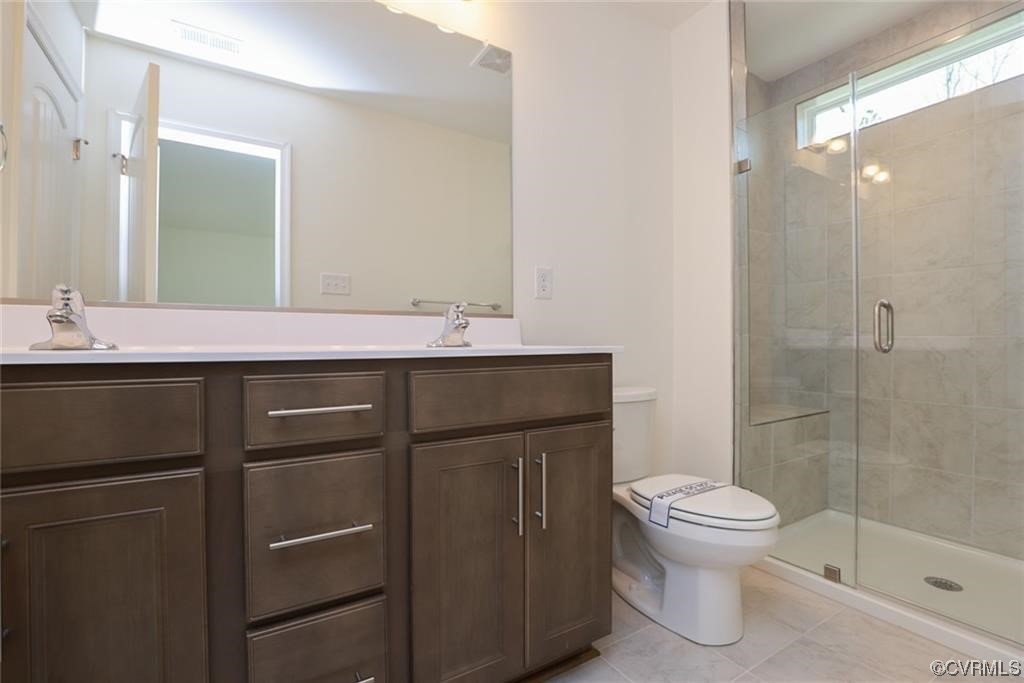 Photo represents the plan not the actual home. Design selections may vary. Ensuite primary bath features a double vanity and luxury tiled shower.
