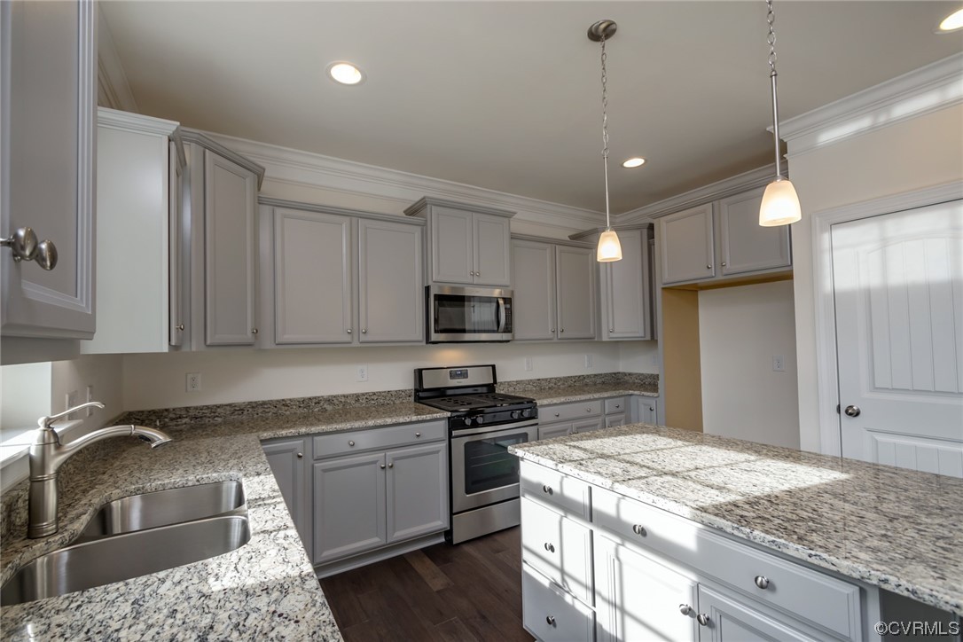 Photo represents the plan, not the actual home. Design selections may vary. The UPGRADED kitchen showcases stunning two-tone cabinets, sparkling white quartz counters, gas cooking, an island, pantry, and stainless steel appliances with an LED recessed lighting package.