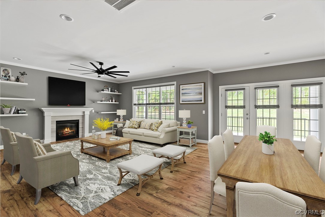 Living room with light hardwood flooring, a fireplace, ornamental molding, and ceiling fan