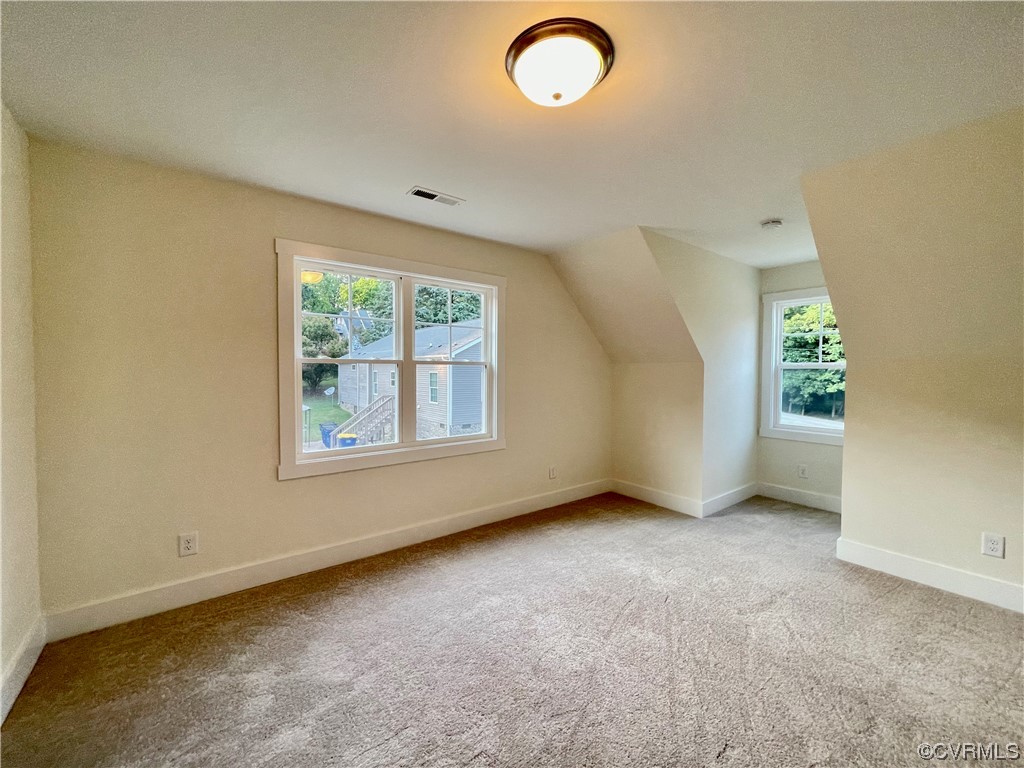 upstairs bedroom featuring carpet and natural light