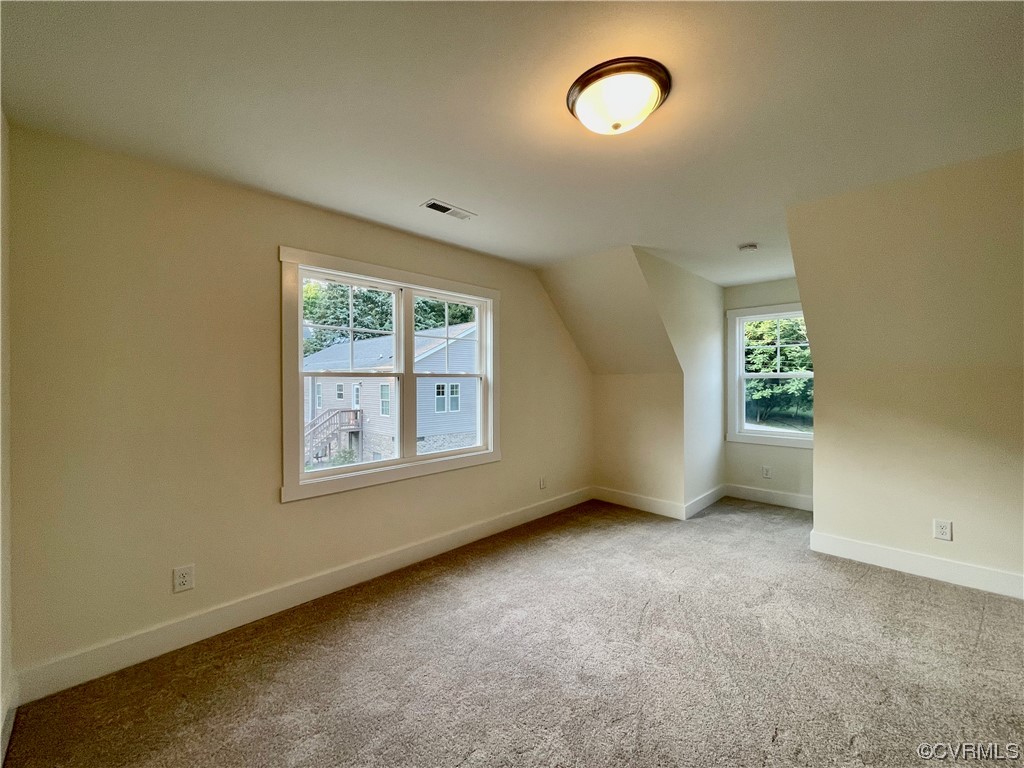 Upstairs bedroom featuring plenty of natural light and carpet