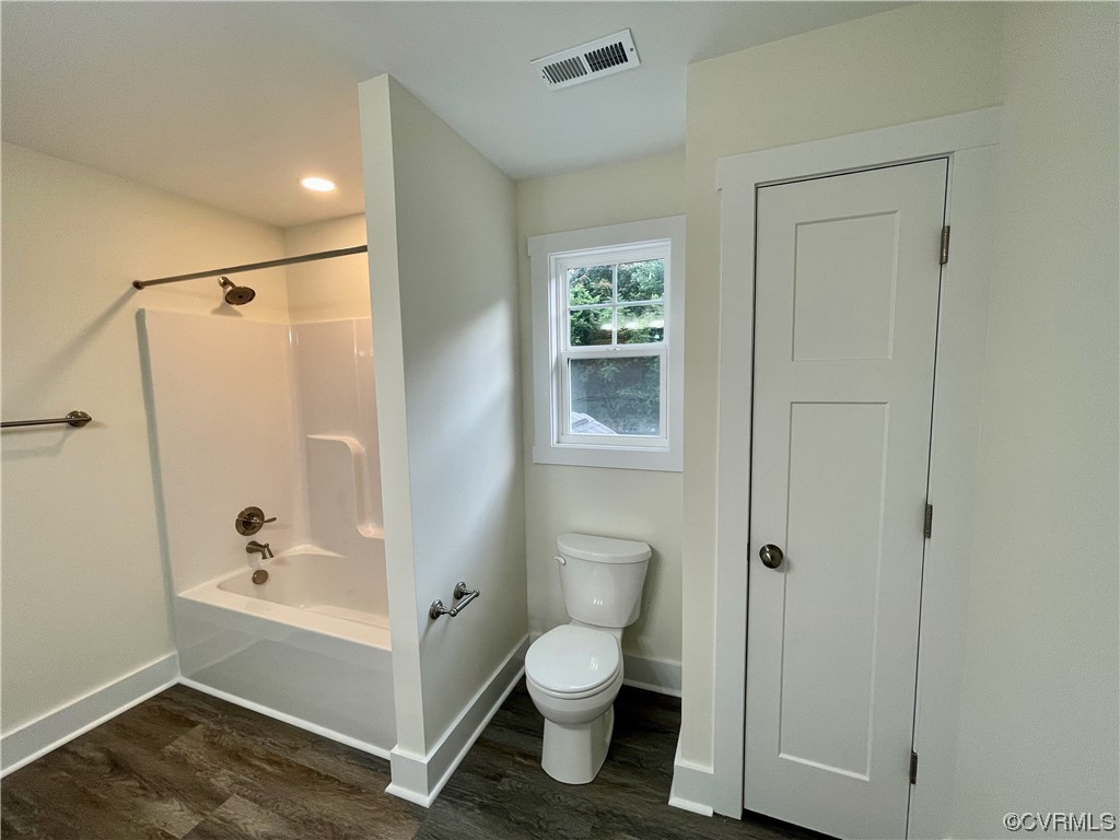 Bathroom featuring natural light, toilet, and shower / tub combination