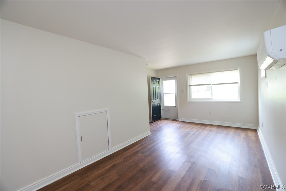 Empty room featuring natural light and hardwood flooring