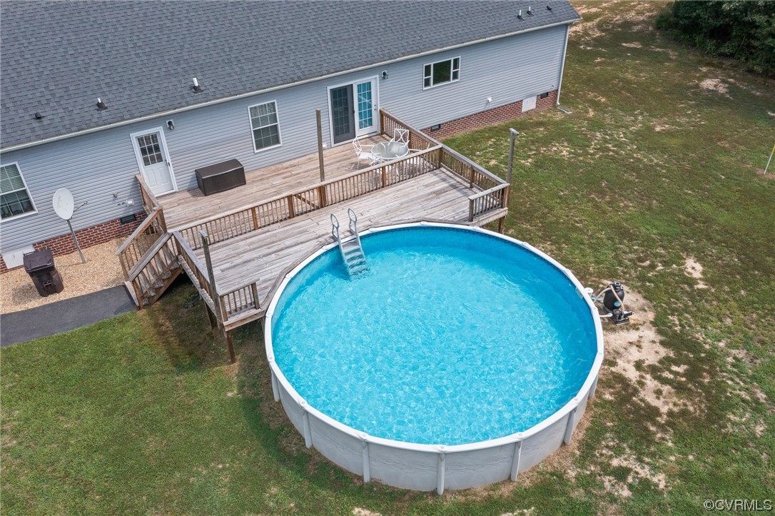 View of swimming pool featuring a yard and a deck