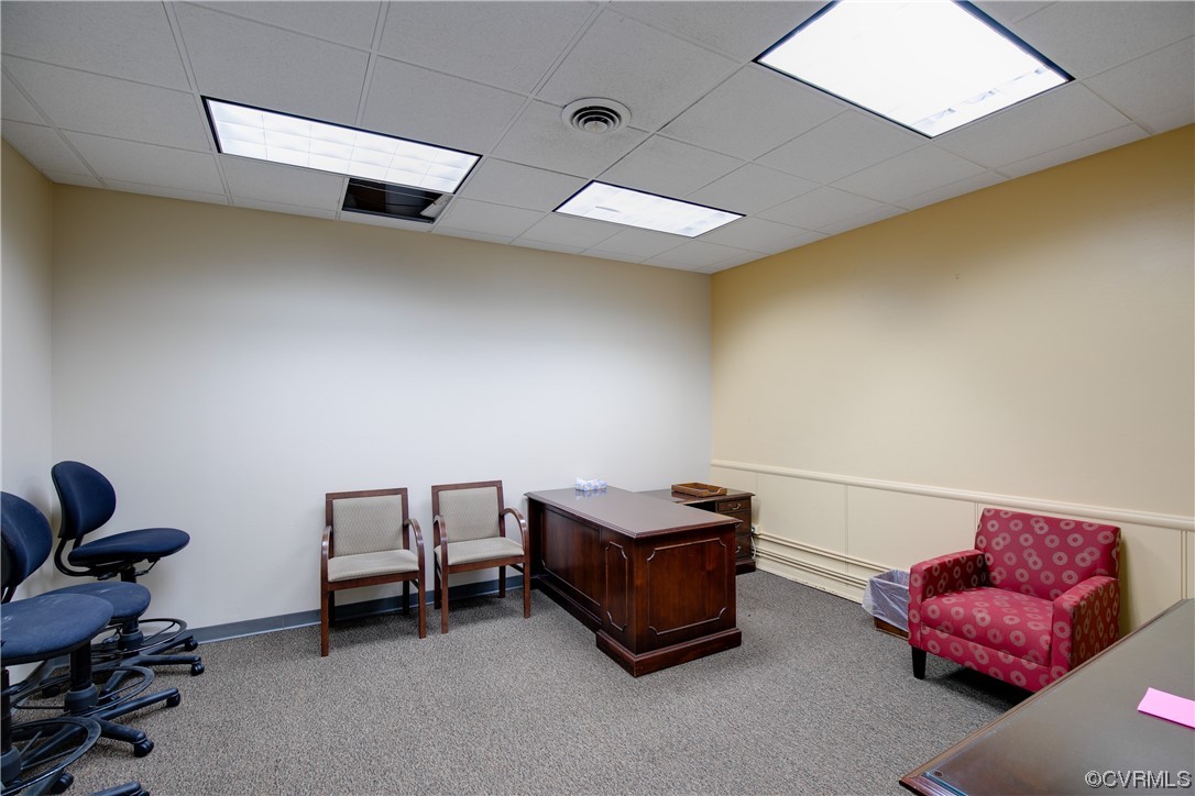 Office with a drop ceiling and light carpet
