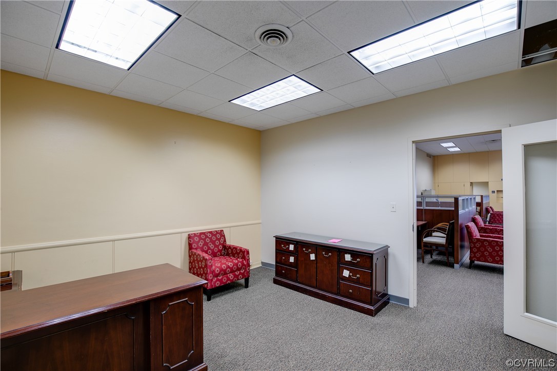 Office space with a drop ceiling and light carpet