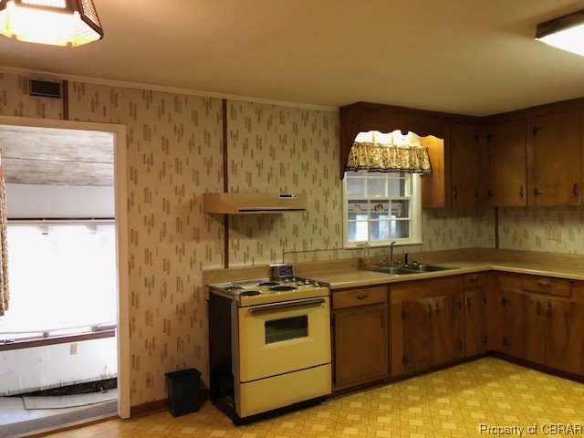 Kitchen featuring range, light countertops, extractor fan, and light