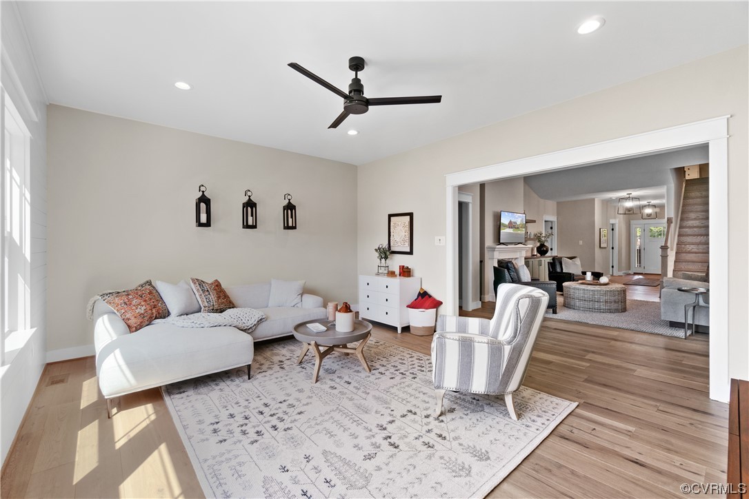 Living room with ceiling fan and light wood-type flooring