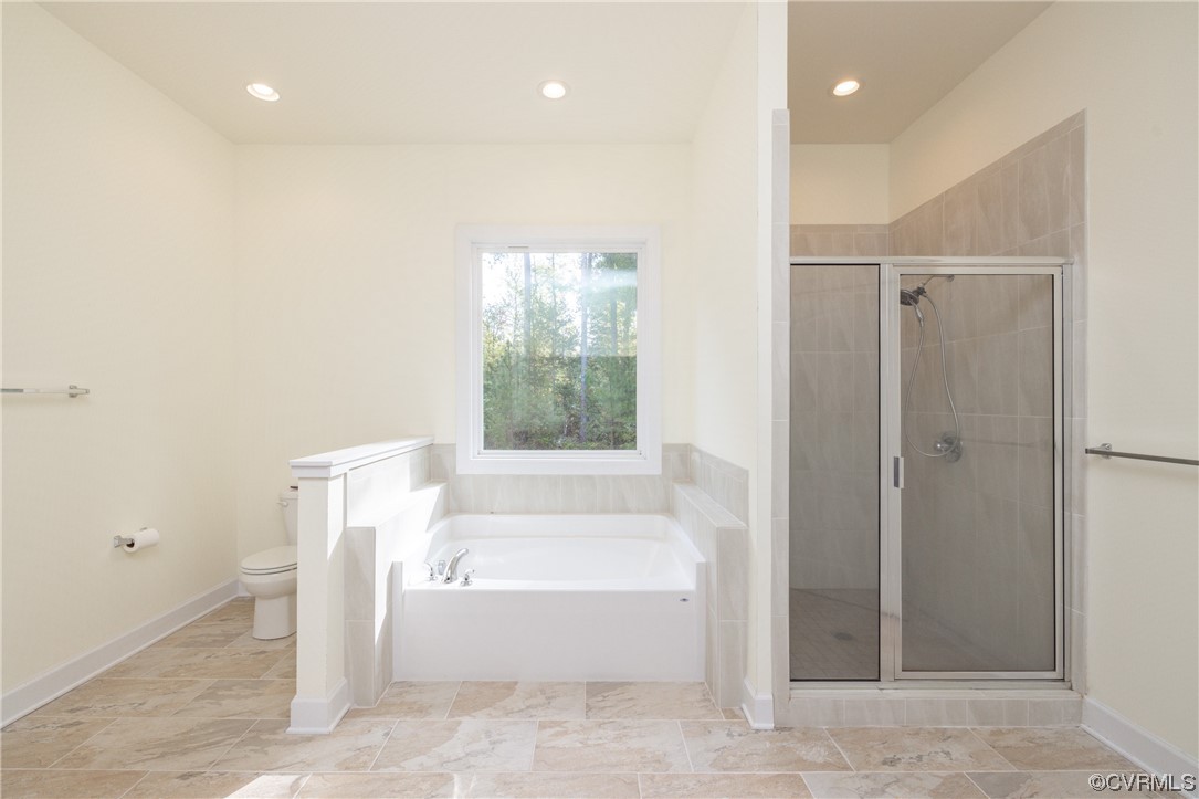 Master bathroom with shower with separate bathtub, tile flooring, and toilet