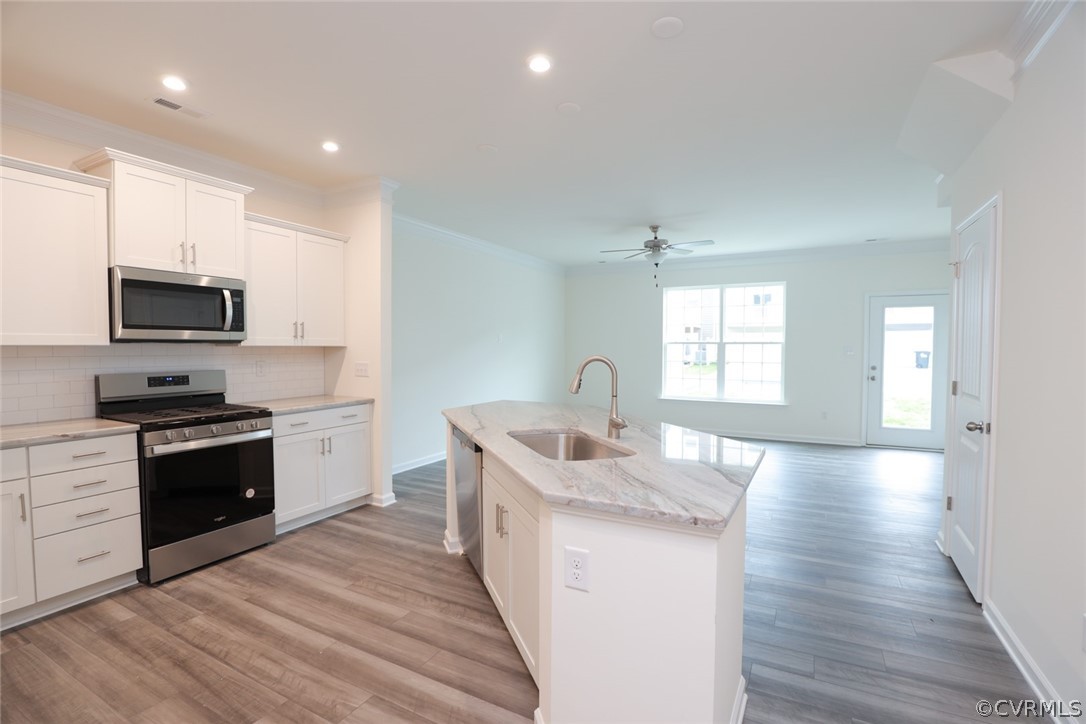 Photo represents the plan, not the actual home. Design selections may vary. Kitchen with white cabinetry, granite counters, island and pantry, and tile backsplash.