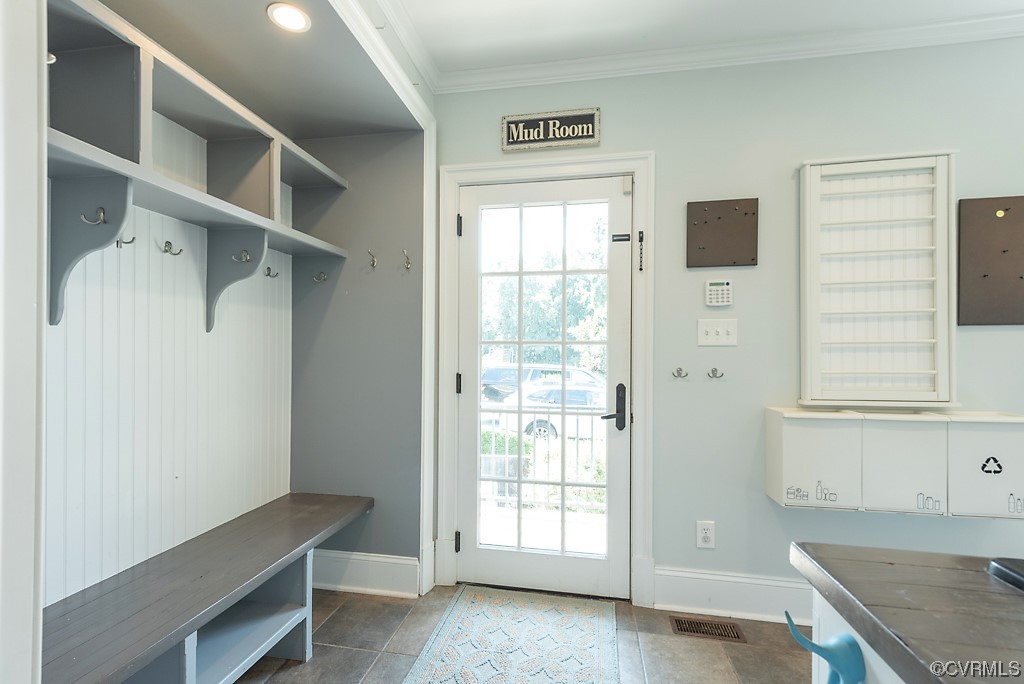 Mudroom with plenty of natural light, tile floors, and crown molding