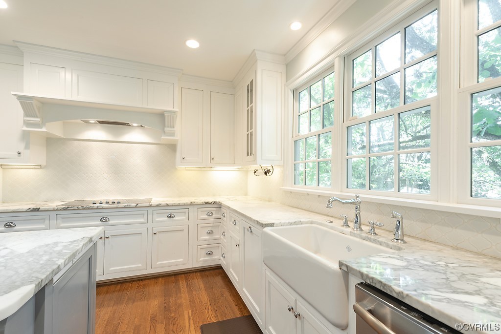 Kitchen featuring tasteful backsplash, white cabinets, dark hardwood floors, crown molding, and dishwasher