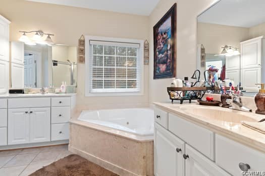 Bathroom featuring tiled bath, tile flooring, and oversized vanity