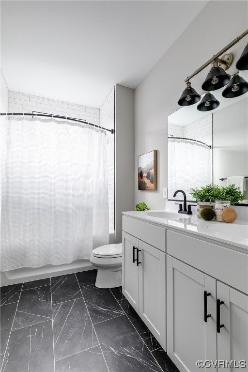 Bathroom featuring tile floors, vanity with extensive cabinet space, and toilet