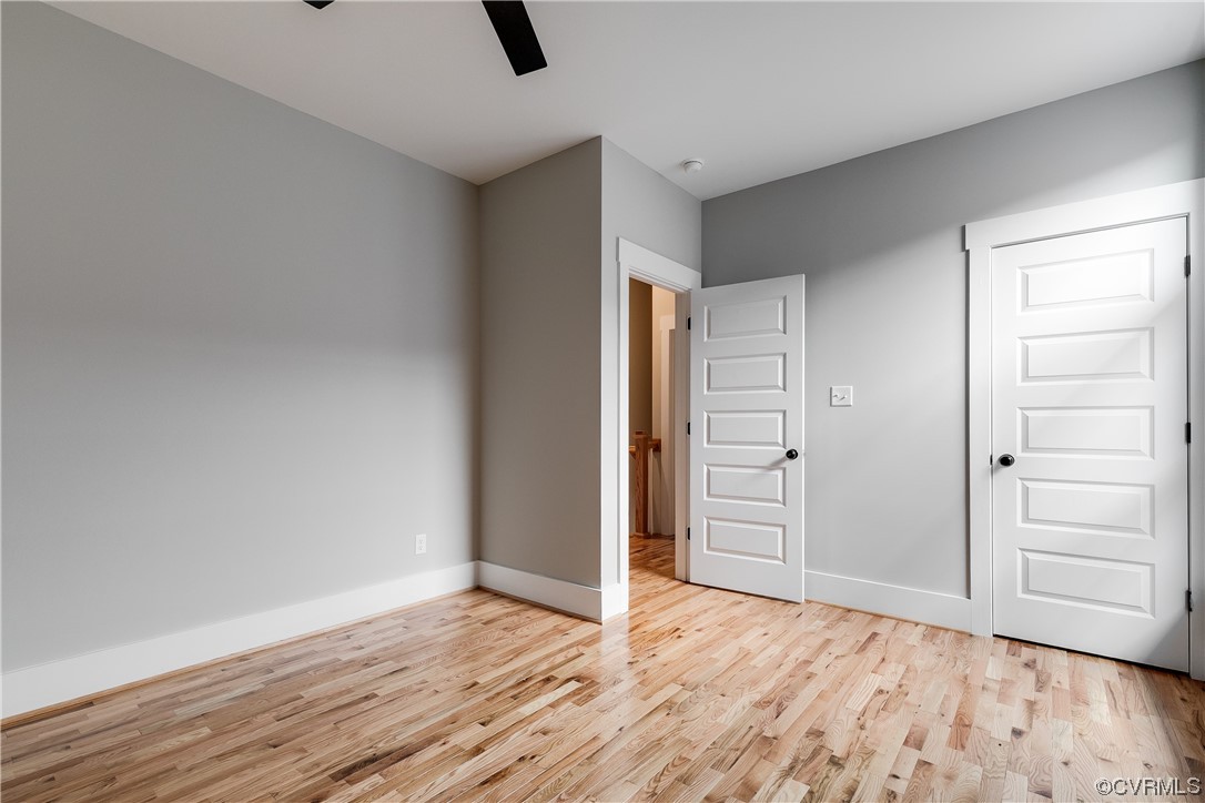 Hardwood floored spare room with ceiling fan