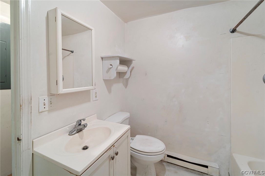Full bathroom featuring shower / tub combination, vanity, a baseboard heating unit, and toilet