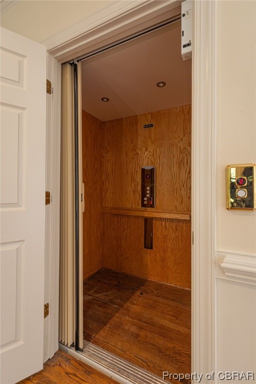 Elevator that goes from the basement to 2nd floor featuring dark hardwood / wood-style flooring