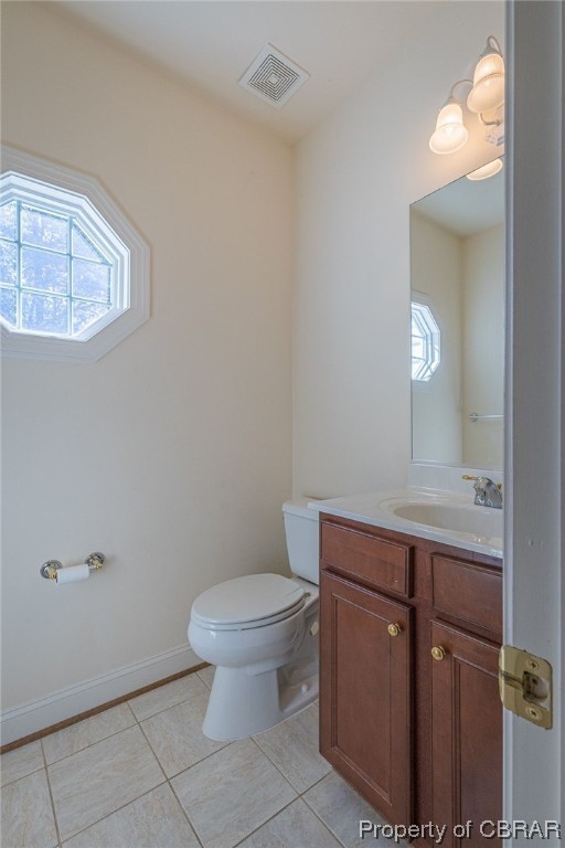 Half Bathroom on 1st floor with a wealth of natural light, tile floors, large vanity, and toilet