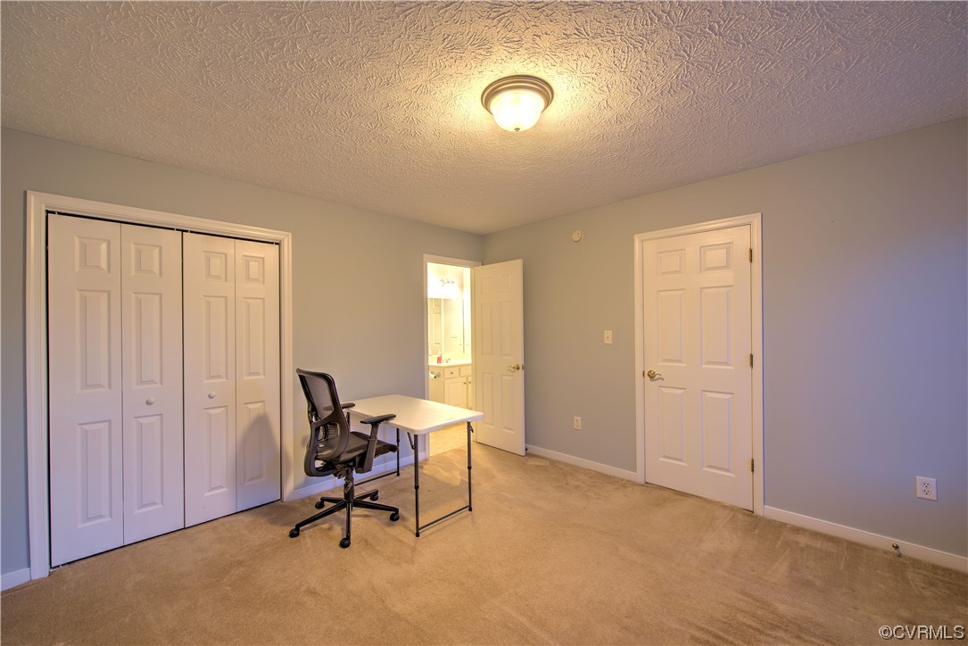 1st Floor Bedroom with full bath access. Doubles as an Office area with light carpet and a textured ceiling