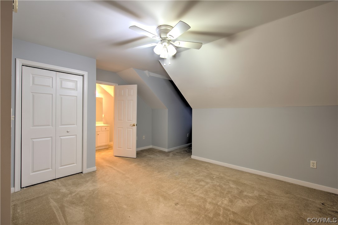 3rd bedroom is on second floor with full bath featuring ceiling fan, light carpet, and vaulted ceiling