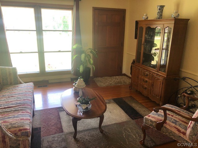 Living room featuring plenty of natural light and dark hardwood / wood-style flooring