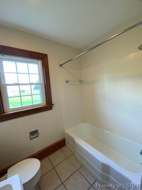 Bathroom featuring tile flooring, toilet, and tub / shower combination