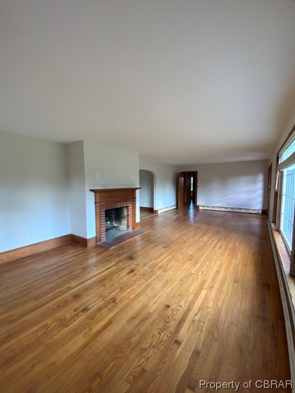 Unfurnished living room featuring a fireplace and dark hardwood / wood-style floors