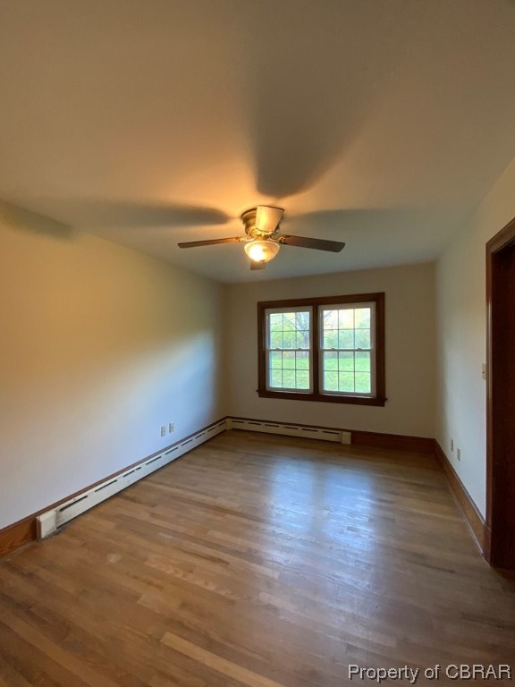 Unfurnished room with hardwood / wood-style floors, ceiling fan, and a baseboard radiator