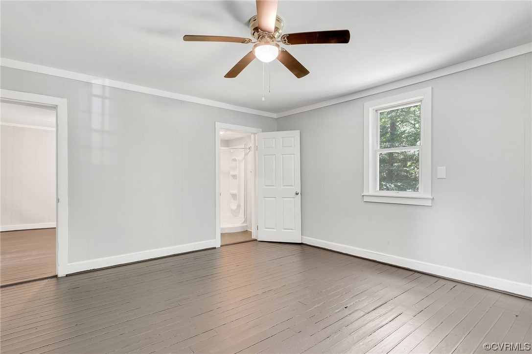 Empty room with hardwood / wood-style floors, ceiling fan, and ornamental molding