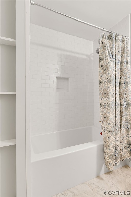 Bathroom featuring shower / bathtub combination with porcelain tile flooring