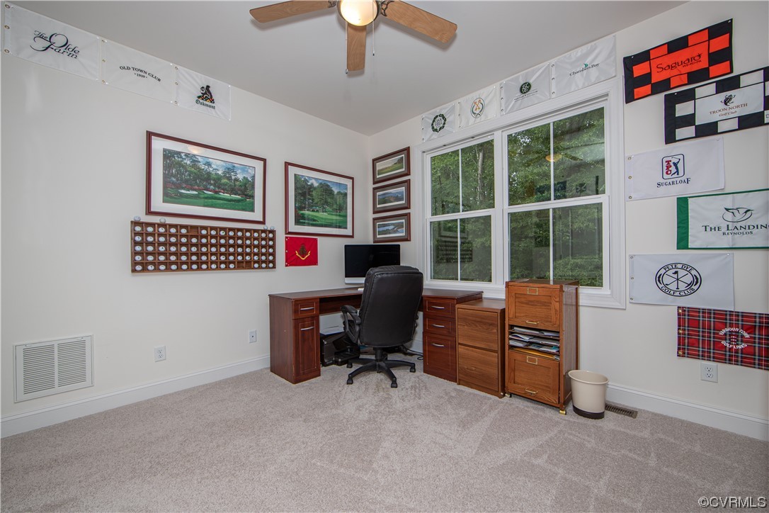Carpeted office featuring ceiling fan