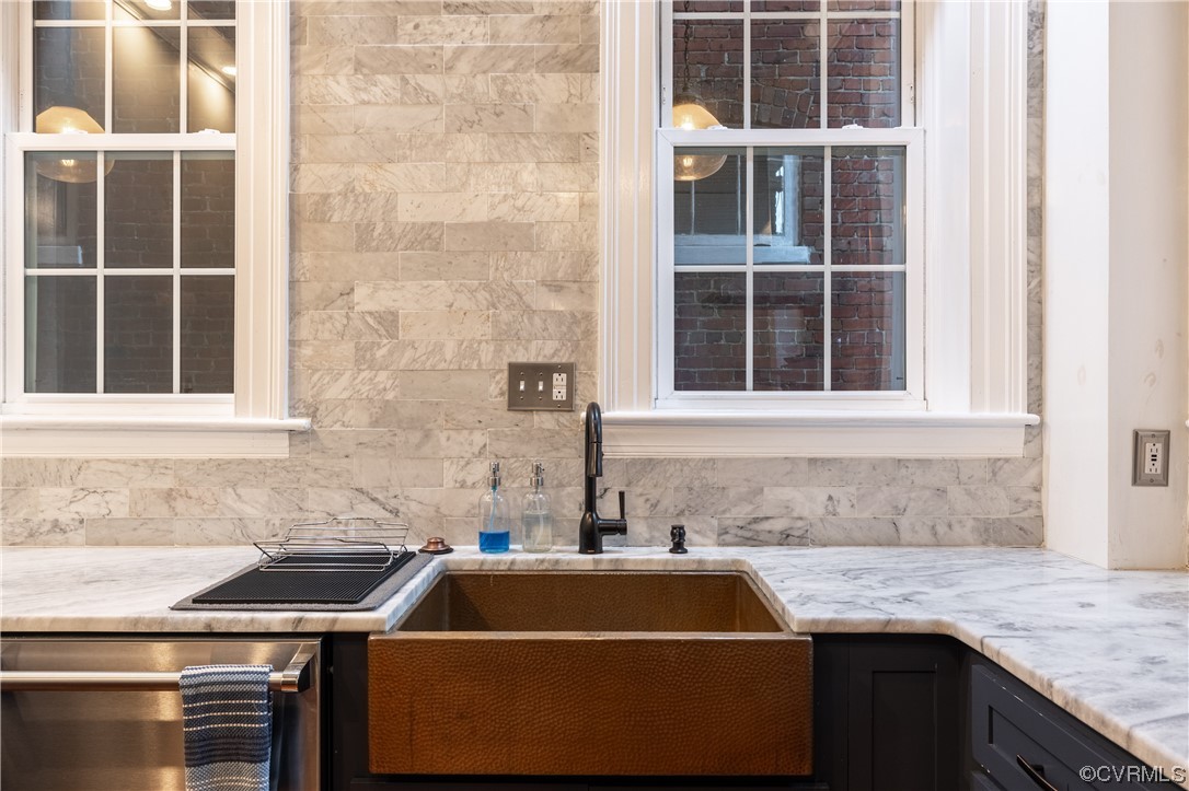 Kitchen featuring light stone counters and sink