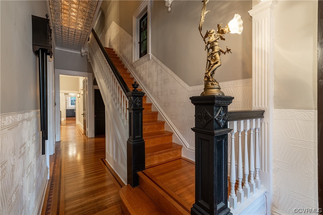 Staircase with crown molding and hardwood / wood-style floors