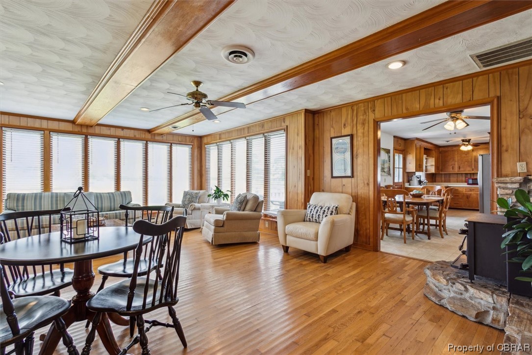 Dining space featuring light hardwood / wood-style flooring, ceiling fan, and wood walls