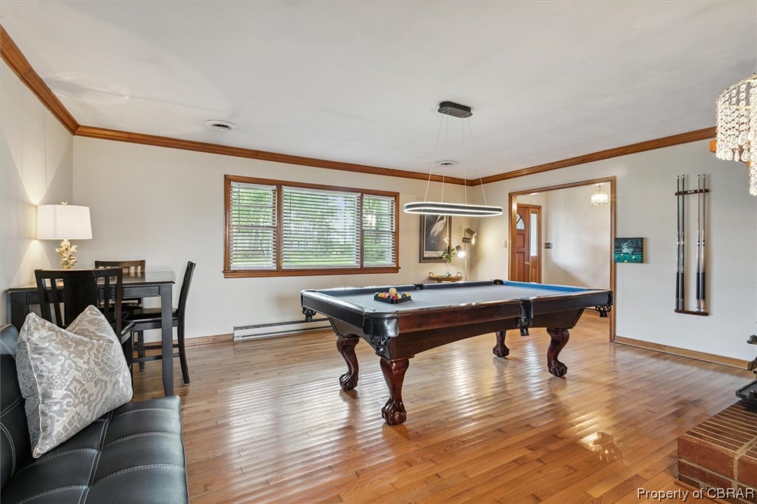 Rec room with ornamental molding, a baseboard heating unit, light hardwood / wood-style floors, and pool table