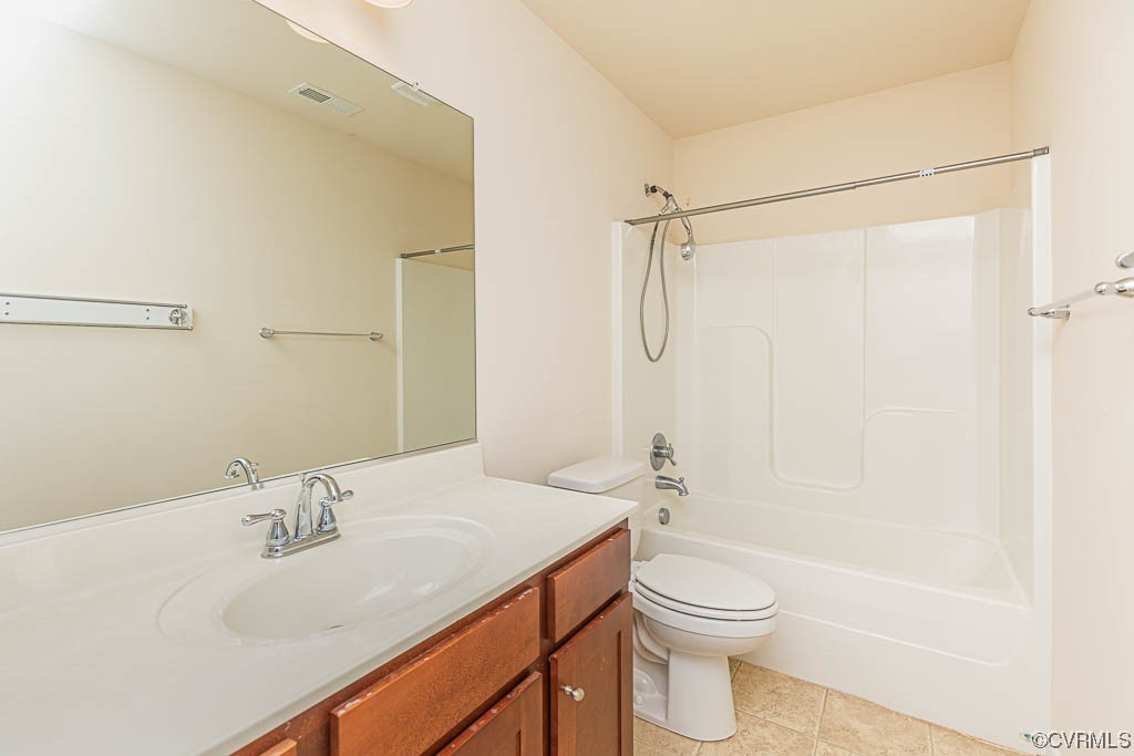 Full bathroom with toilet, tile floors, shower / washtub combination, and vanity