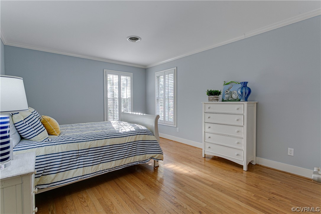 Guest Bedroom with light hardwood and crown molding