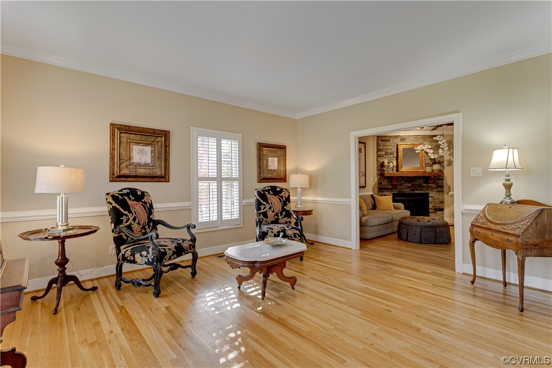 Living room area with light wood flooring, crown and chair molding