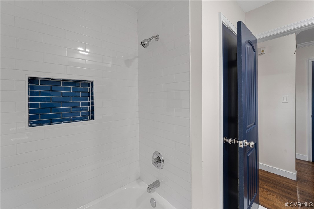 Bathroom featuring tiled shower / bath and hardwood / wood-style flooring