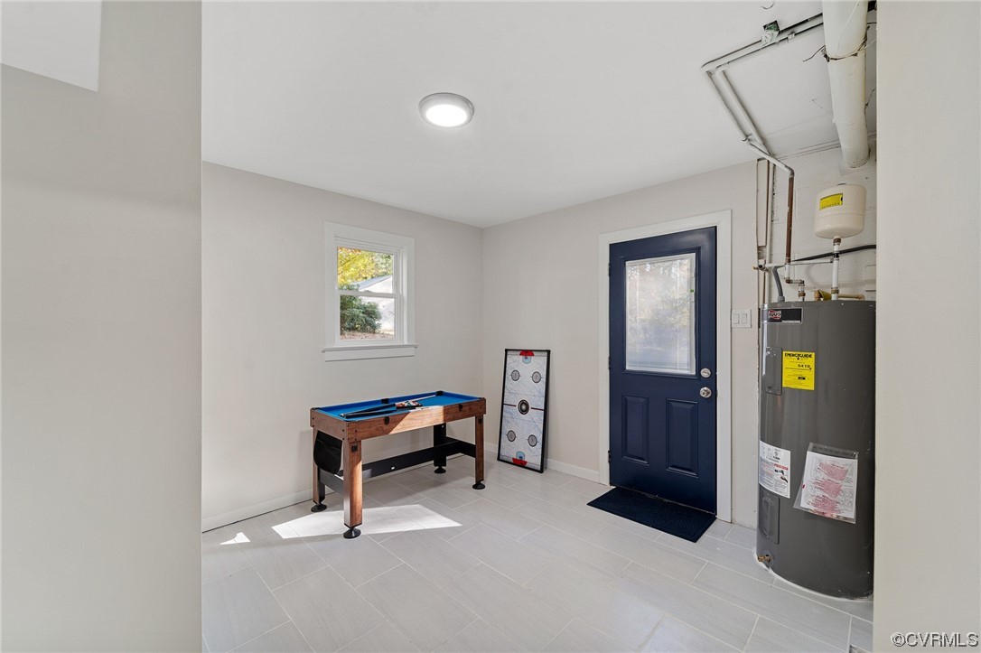 Tiled entryway featuring billiards and electric water heater