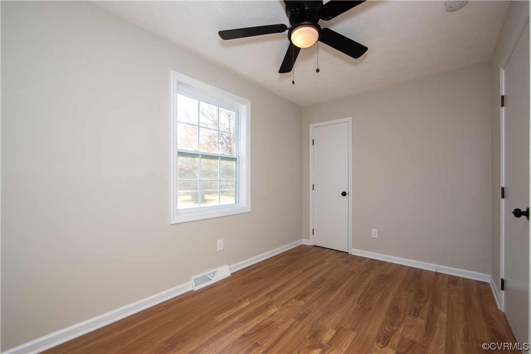 Unfurnished room with ceiling fan and hardwood / wood-style flooring