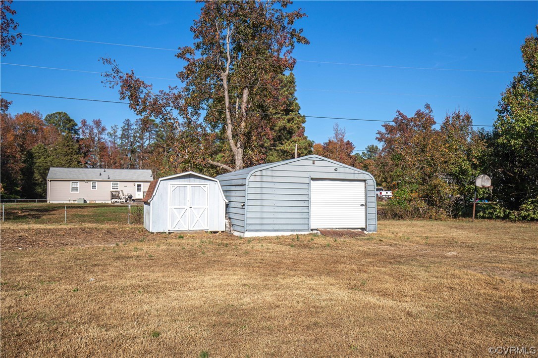 View of outdoor structure featuring 2 storage sheds. Larger shed has brand new garage door.