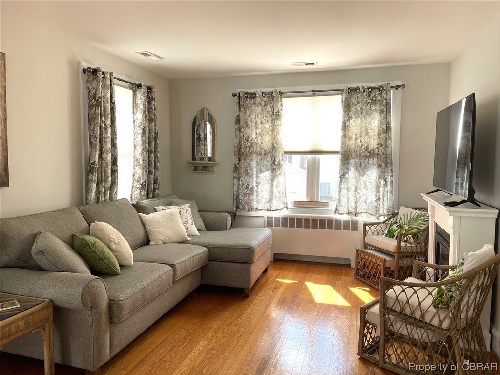 Living room featuring light wood-type flooring and radiator heating unit