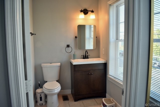 Bathroom featuring vanity, toilet, & tile flooring