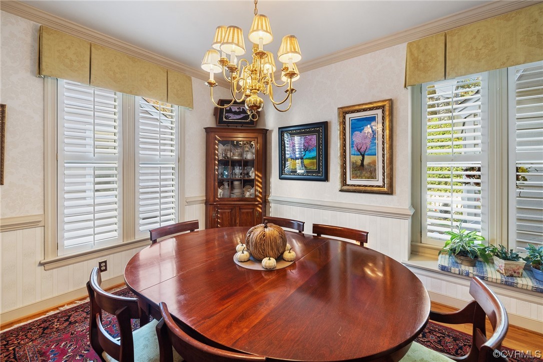 Dining room with hardwood floor, window seat, and crown & chair molding