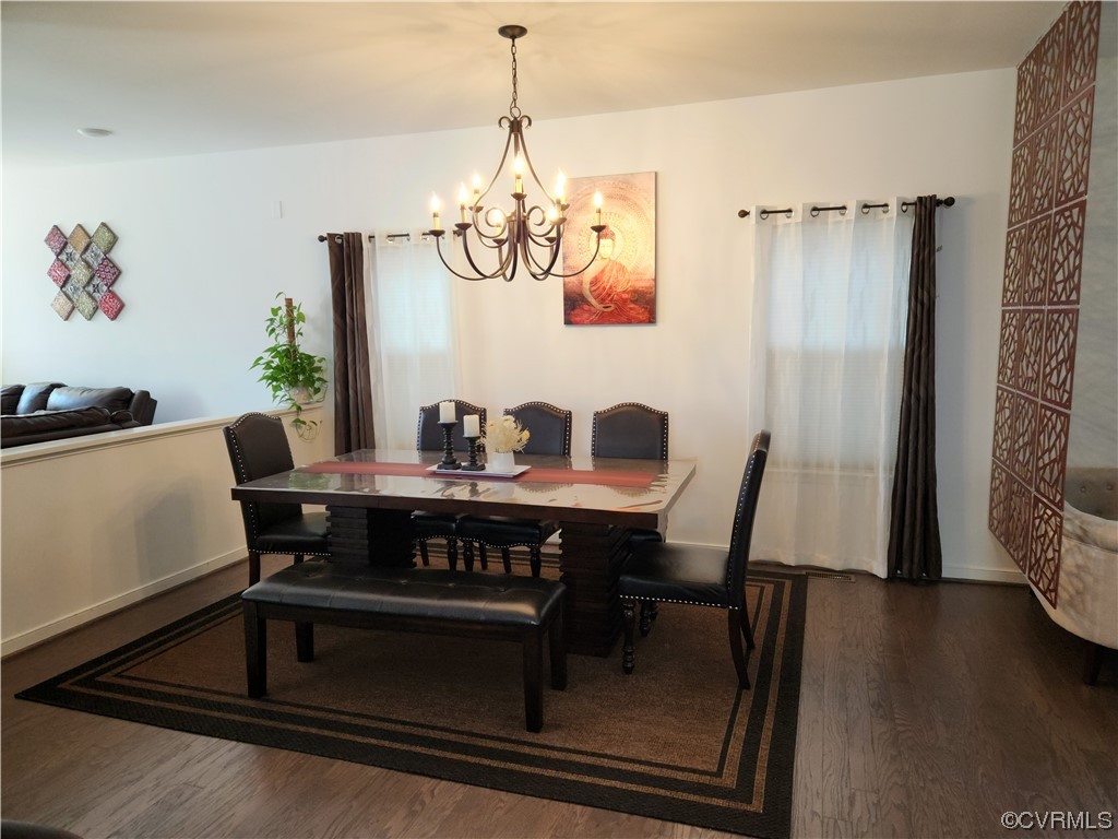 Dining space featuring a chandelier and dark hardwood / wood-style flooring
