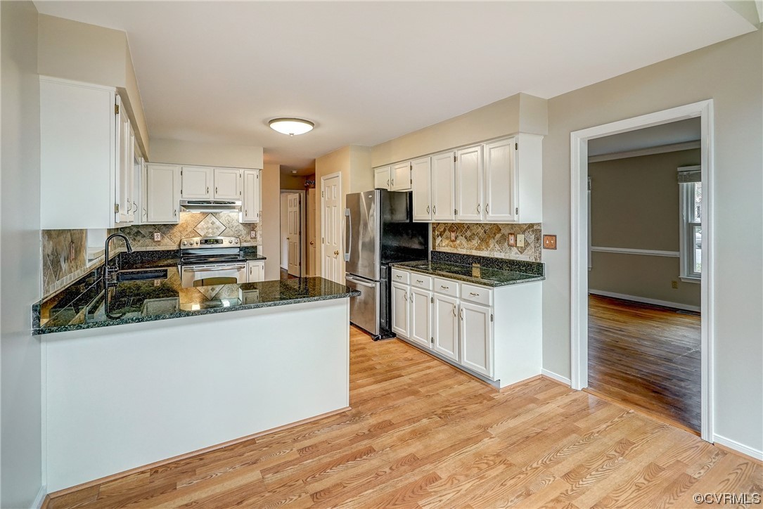 Kitchen featuring stainless steel appliances, light wood-type flooring, and white cabinetry
