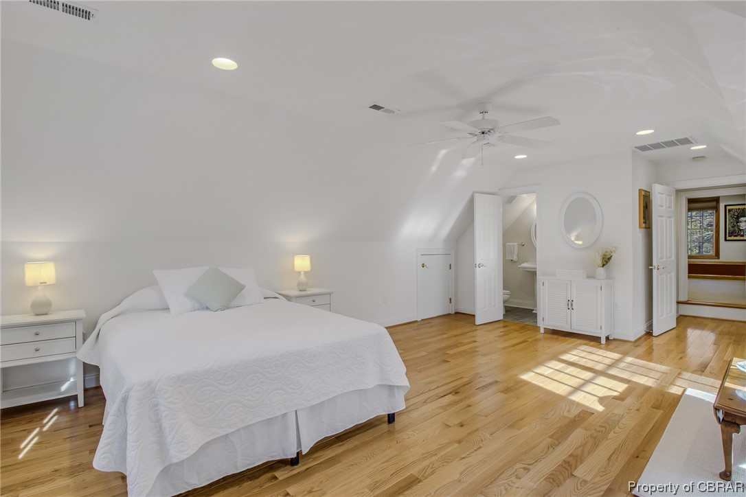Second floor bedroom with hardwood floors, and vaulted ceiling
