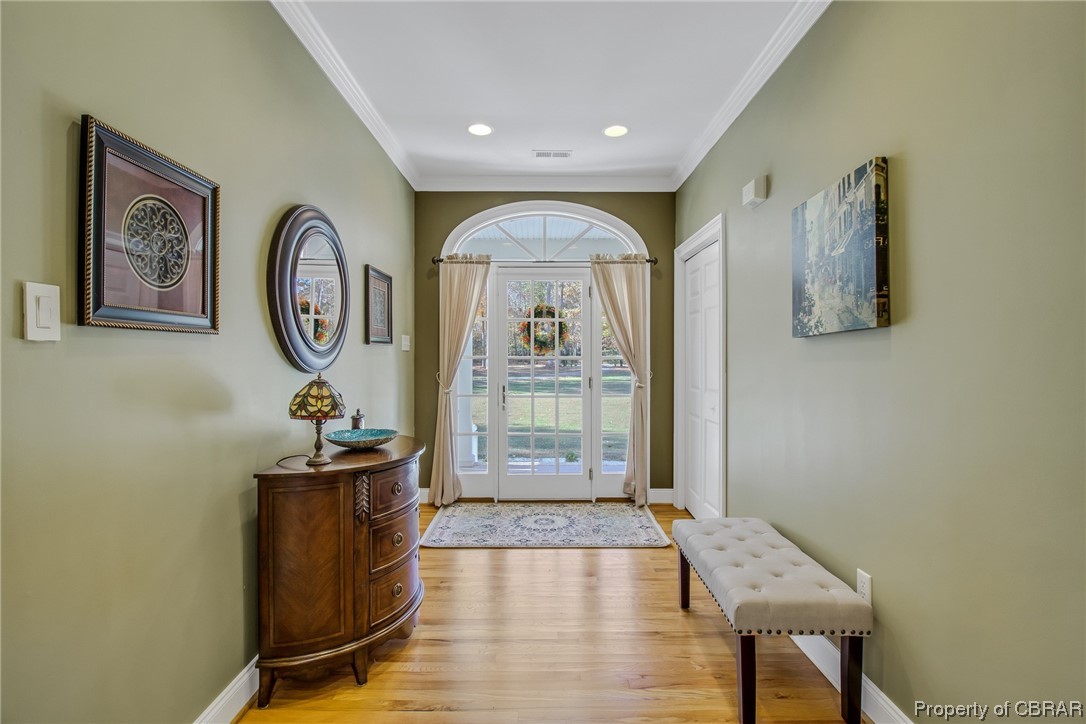Entryway featuring crown molding and hardwood floors